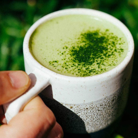 Cup of creamy green tee with herbs