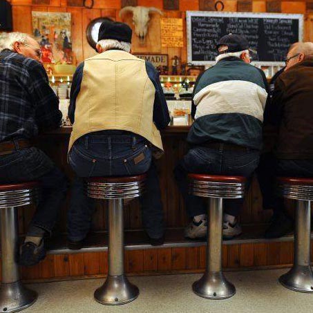Old gentleman in conversation on counter stools